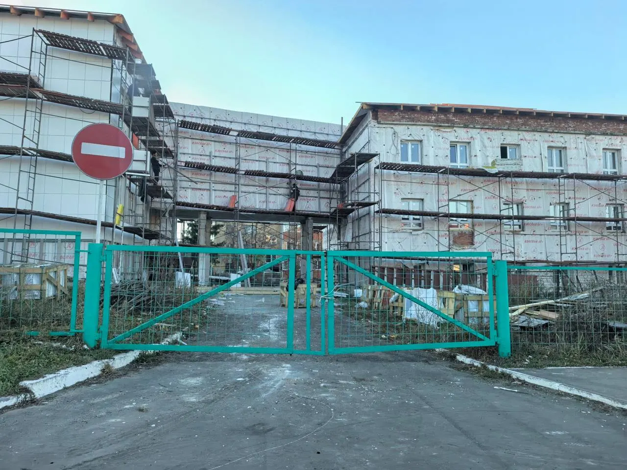 Капитальный ремонт школы в посёлке Опытный идёт по плану, но кровельные работы затягиваются, вокруг — леса и строительные материалы.
